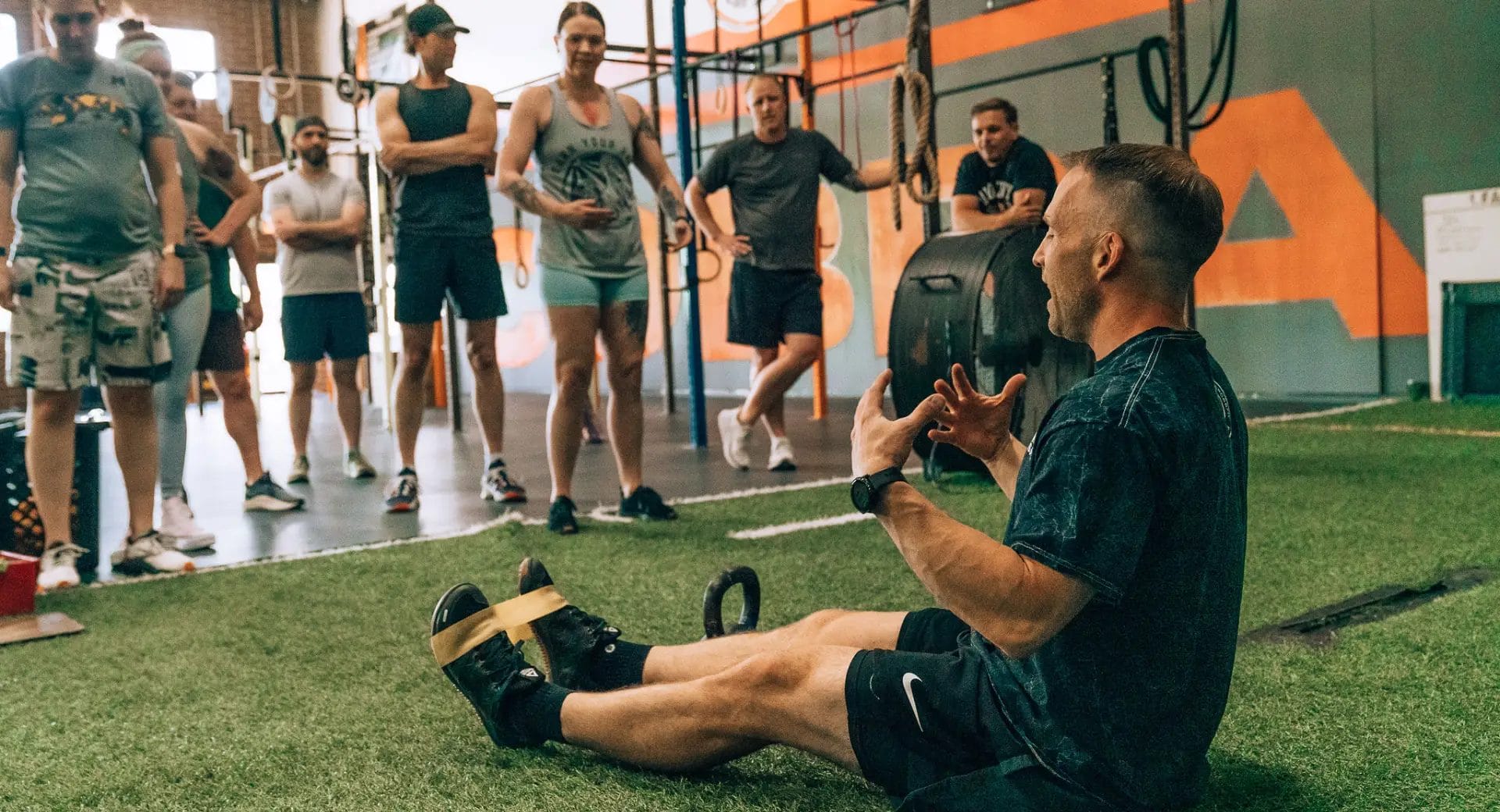 Coach demonstrating workout techniques to gym members
